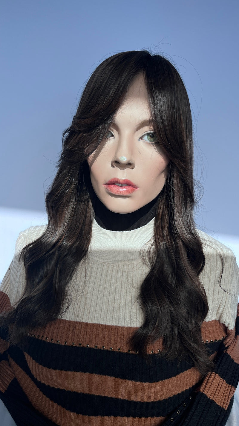 Front view of the Sari Luxe wig with a side-swept fringe and soft waves.