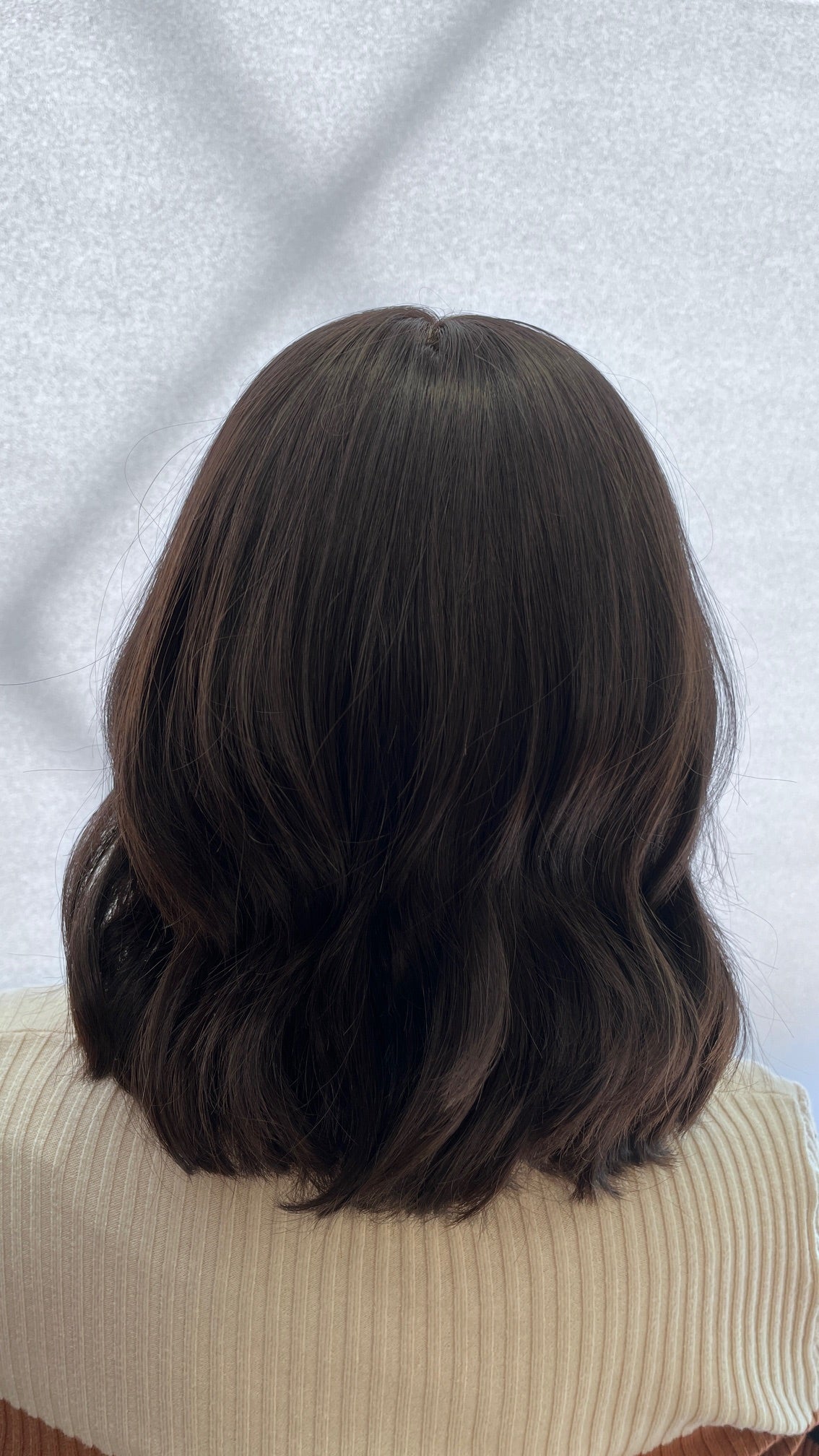 Back view of the dark brown Fortune wig with soft waves