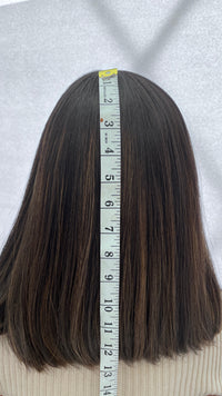 Back view of the Gali wig beside a measuring tape