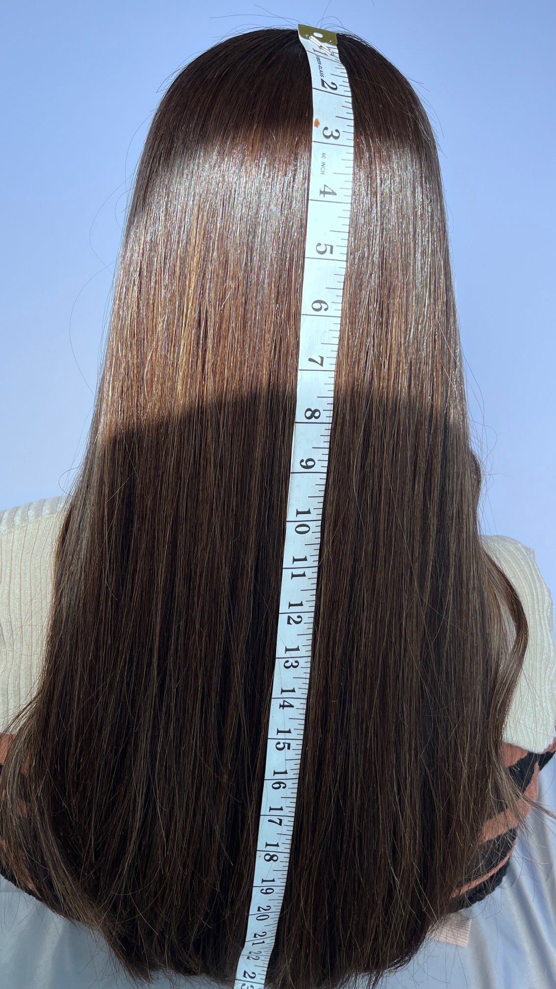 Back view of the Mazali lace top wig beside a measuring tape