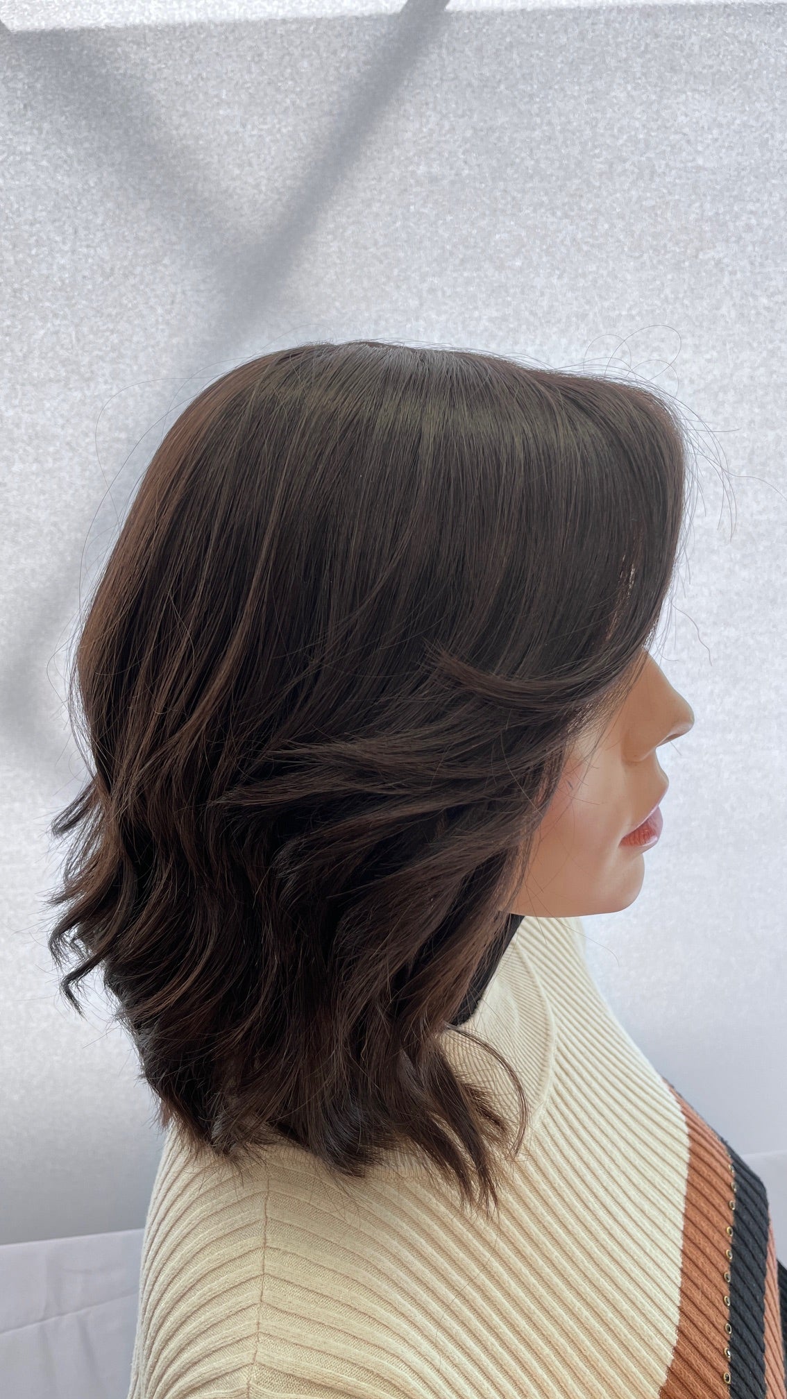 Side view of the Fortune wig's face-framing layers and soft waves