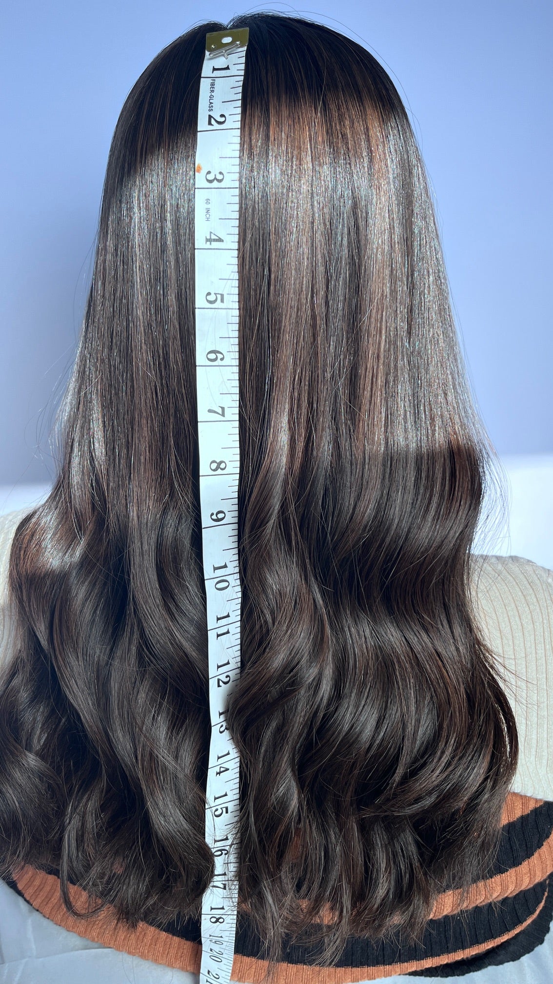 Back of the Sari Luxe wig with a measuring tape beside the hair.
