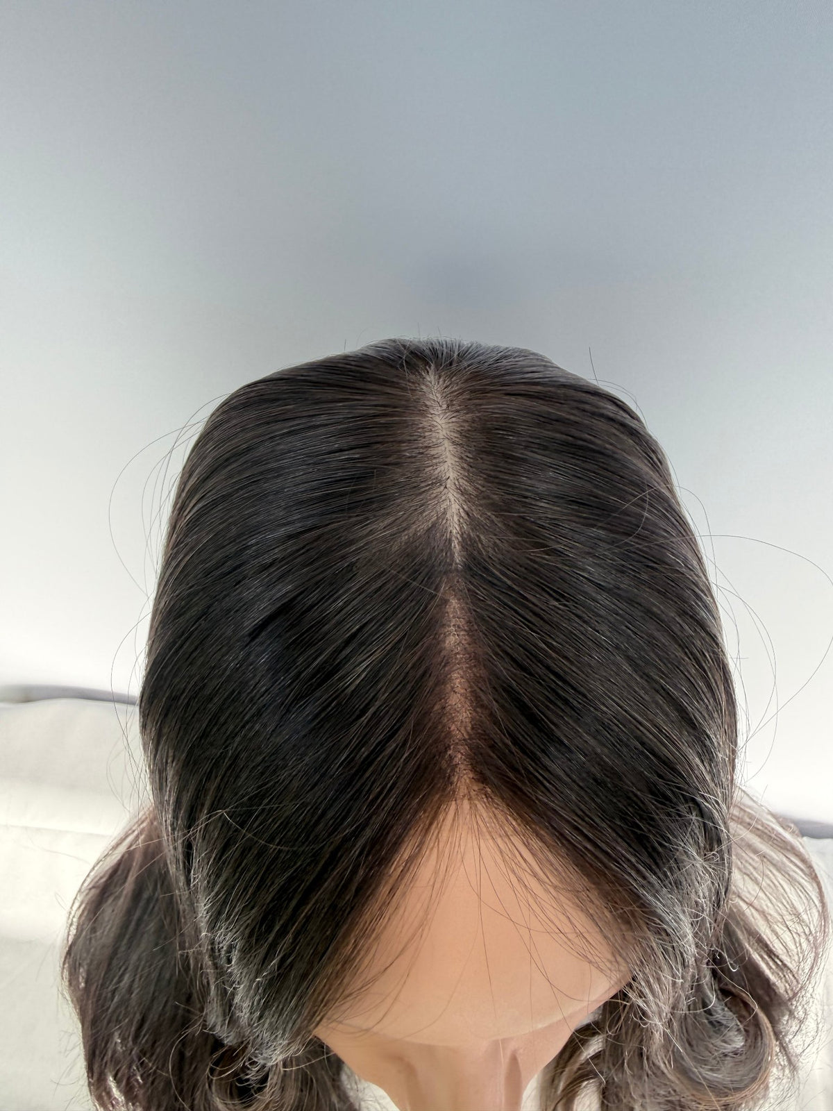 Top view of the Tuni wig showing its part and front hairline.